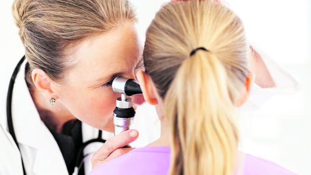 Doctor Analyzing Girl's Ear With Otoscope
