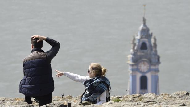 Touristen vor dem Hintergrund der Kirche Dürnstein in der Wachau.