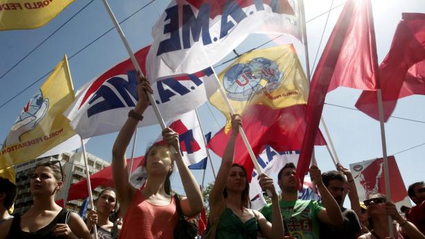 Eine Gruppe von Menschen demonstriert mit Fahnen der World Federation of Trade Unions.