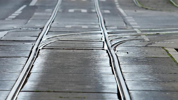 Gleise einer Straßenbahn führen durch eine städtische Umgebung.