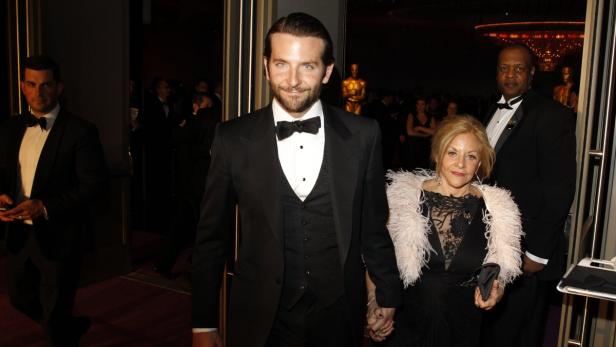 Bradley Cooper führt seine Mutter Gloria Campano über den roten Teppich.