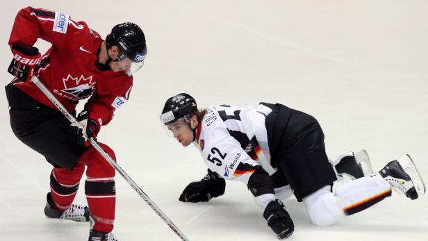 epa00994793 German Alexander Sulzer (R) looks on as Canadian Eric Staal (L) passes by during their prelimary round group C match at the Ice Hockey World Championship in the town of Mytischi, outside Moscow, Russia, 28 April 2007. EPA/ANATOLY MALTSEV