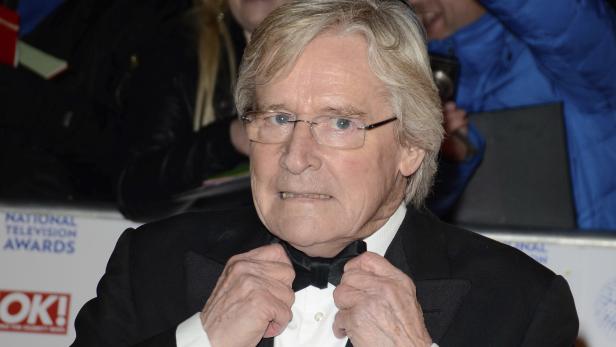 Ein Mann mit Brille und Fliege auf dem roten Teppich.