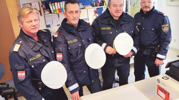Vier österreichische Polizisten stehen in ihren Uniformen in einem Büro.