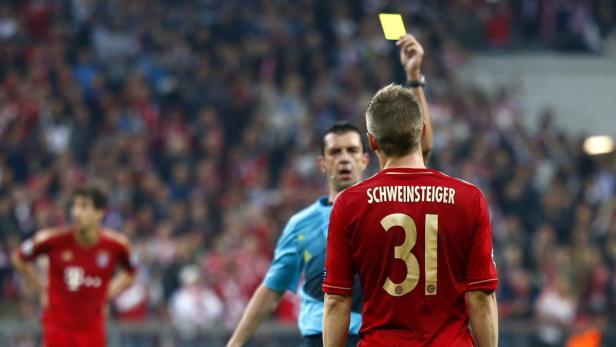 Bayern Munich&#039;s Bastian Schweinsteiger is shown a yellow card by referee Viktor Kassai (C) during their Champions League semi-final first leg soccer match against Barcelona at Arena stadium in Munich April 23, 2013. REUTERS/Michaela Rehle (GERMANY - Tags: SPORT SOCCER)
