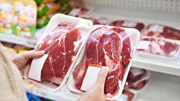 Buyer hands with beef meat packages at grocery
