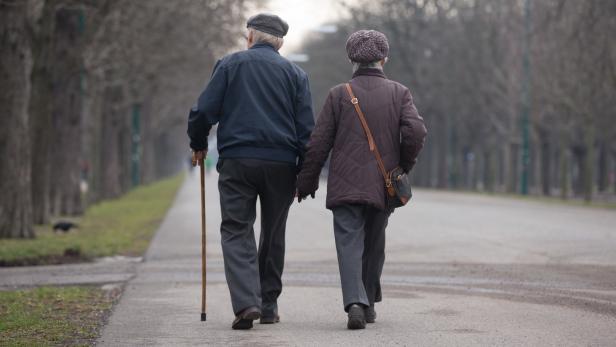Ein Pensionistenpaar spaziert die Prater Hauptallee entlang