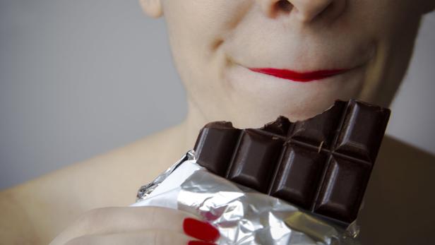 Eine Frau mit einer Tafel Schokolade.