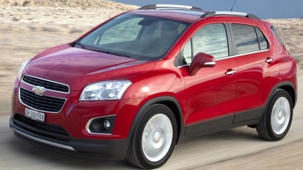 Ein roter Chevrolet Trax fährt auf einer Straße in einer Wüstenlandschaft.
