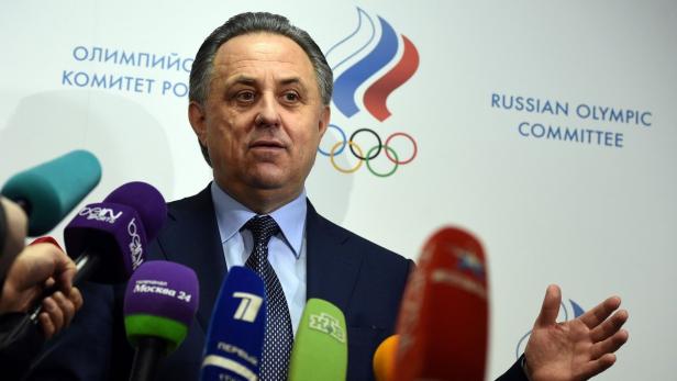 Ein Mann in Anzug steht vor Mikrofonen und dem Logo des Russischen Olympischen Komitees.