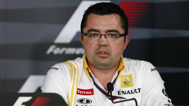 Ein Mann mit Brille und einem Renault-Hemd vor einem Formel-1-Hintergrund.