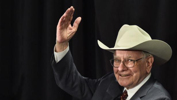 Warren Buffett mit Cowboyhut winkt in die Kamera.