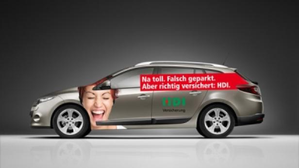 Ein Auto mit einer Werbung der HDI Versicherung, die eine lachende Frau zeigt.