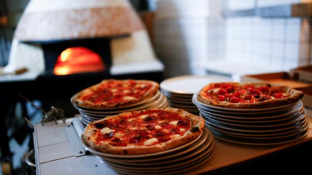 Pizza is prepared inside the Apollo Pizzeria,  in London