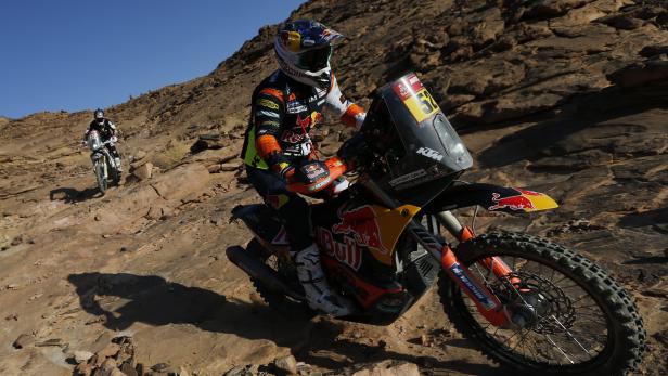 Motorradfahrer bei der Rallye Dakar auf felsigem Untergrund.