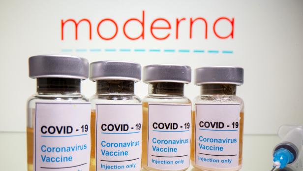 FILE PHOTO: Vials and medical syringe are seen in front of Moderna logo in this illustration