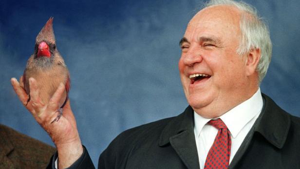 Helmut Kohl lacht, während ein Kardinalvogel auf seiner Hand sitzt.