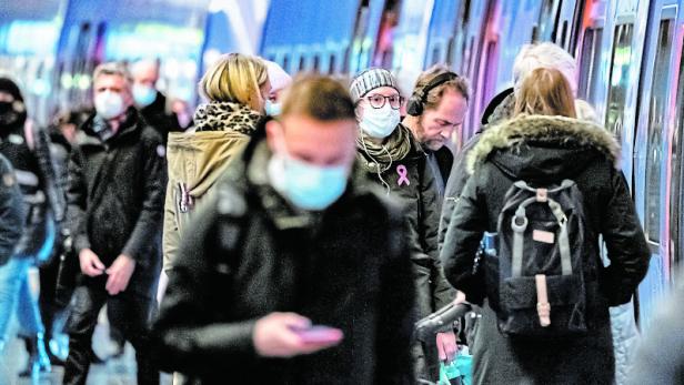 Passengers wearing protective masks walk on a platform at Malmo Central Station amid the coronavirus disease (COVID-19) outbreak in Malmo