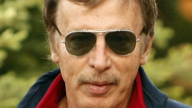 Ein Mann mit Schnurrbart und Pilotenbrille blickt in die Kamera.