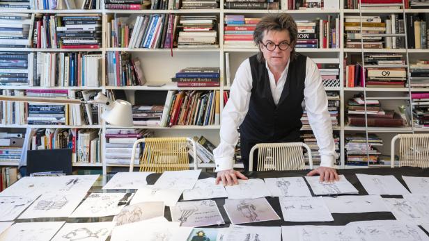Der Kostümbildner Thomas Oláh in seinem Wiener Atelier, wo sich auf seinem Arbeitstisch Entwürfe zu seinen Filmkostümen türmen: „Eine eigene Welt kreieren“
