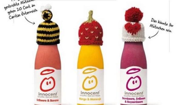 Drei „Innocent“-Smoothies mit gestrickten Mützen in Bienen-, Erdbeer- und Herzform.