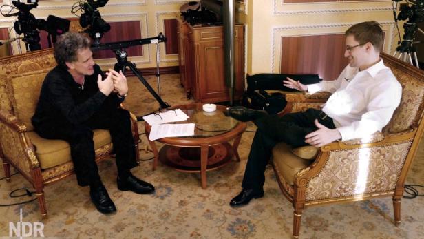 Zwei Männer sitzen in Sesseln und unterhalten sich in einem Fernsehstudio.