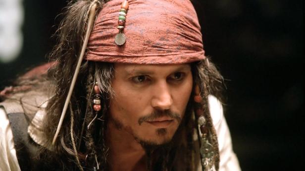 Johnny Depp als Captain Jack Sparrow mit rotem Kopftuch und Zöpfen mit Perlen.