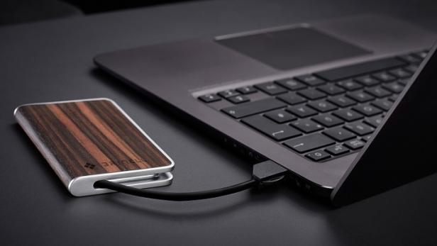 Eine externe Festplatte mit Holzgehäuse ist an einen Laptop angeschlossen.