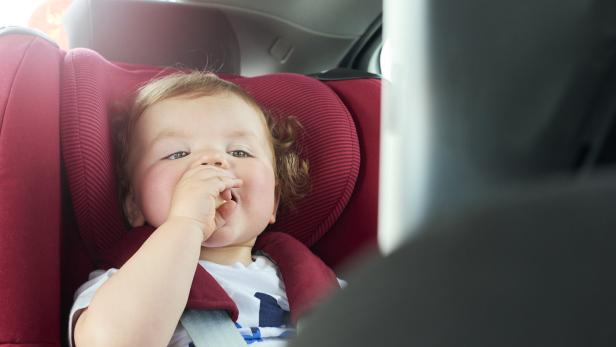Baby boy in car seat watching DVD