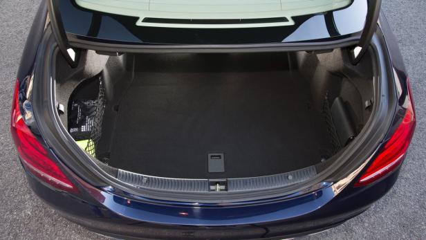 Der offene Kofferraum eines blauen Autos mit Erste-Hilfe-Kasten an der Seite.