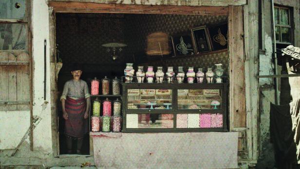 Ein Mann steht in einem Süßwarenladen mit Gläsern und Süßigkeiten.