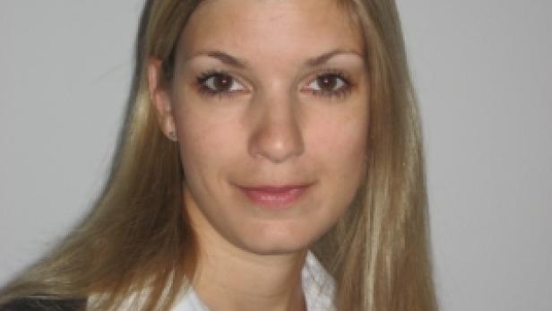 Porträt einer Frau mit blonden Haaren und einem dunklen Blazer.