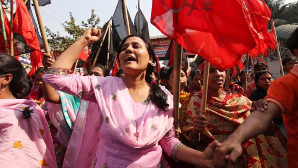 epa03487886 Garment workers shout slogans as they attend a mourning procession for the death of the workers of the Ashlia fire accident in Dhaka, Bangladesh 27 November 2012. More than 100 people were killed after a devastating fire took place at Tazreen Fashions Limited garments factory at Nischintapur, in Savar on the outskirts of Dhaka, Bangladesh, late on 24 November 2012 EPA/ABIR ABDULLAH