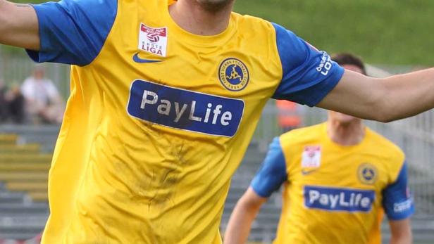 Ein Fußballspieler in einem gelb-blauen Trikot mit dem Aufdruck „PayLife“.