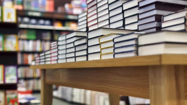 Books stacked on table at bookstore