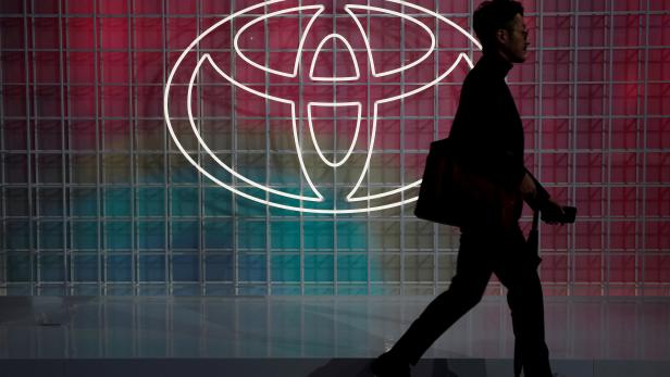 FILE PHOTO: A man walks past a Toyota logo at the Tokyo Motor Show