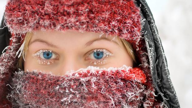 Woman's face covered in hat and scarf in winter