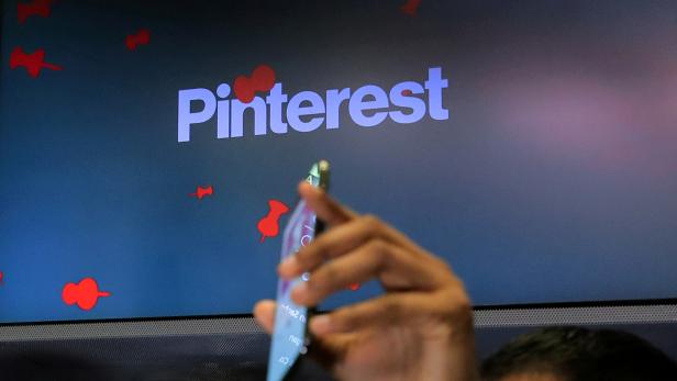 FILE PHOTO: A guest hold up a phone during the Pinterest Inc. IPO on the floor of the NYSE in New York