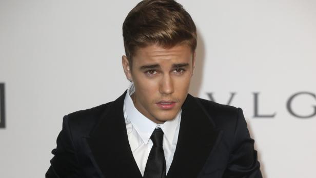 Justin Bieber in einem schwarzen Anzug mit Krawatte.
