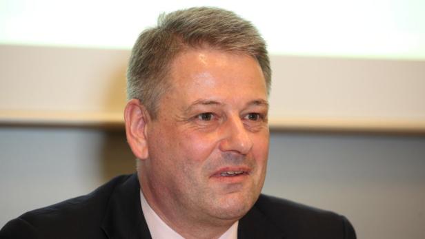 Porträt eines Mannes in einem dunklen Anzug.