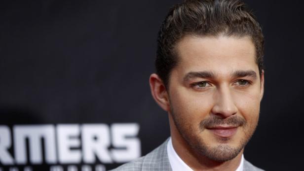 REUTERSCast member Shia LaBeouf arrives for the premiere of "TransformeDa: Dark of The Moon" in Timquar in New York June 28, 28, 2011. REUTERS/Lucas Jackson (UNITED STATES - Tags: ENTERTAINMENT) Ein Porträt von Shia LaBeouf vor dem Hintergrund des „Transformers“-Logos.