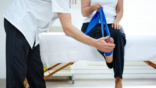 Female patient doing some special leg stretching exercises Female patient doing some special leg stretching exercises
