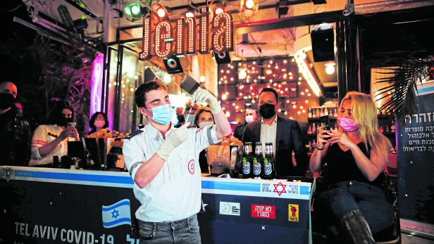 FILE PHOTO: A medical worker prepares to administer a vaccination against the coronavirus disease (COVID-19) as part of a Tel Aviv municipality initiative offering a free drink at a bar to residents getting the shot, in Tel Aviv