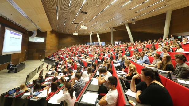 Ein voll besetzter Hörsaal mit Studierenden während einer Vorlesung.