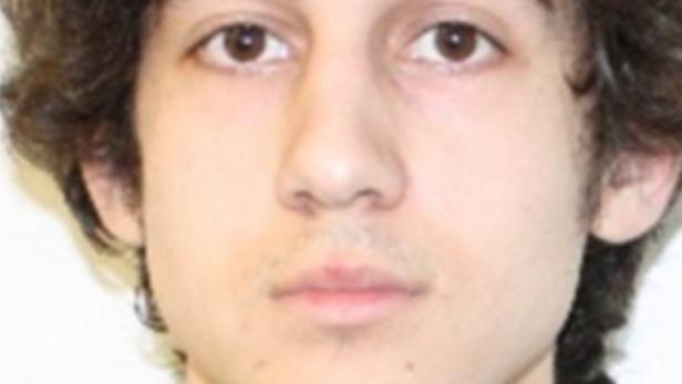 Porträt eines jungen Mannes mit braunen Augen und lockigem Haar.