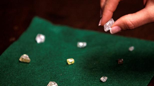 FILE PHOTO: A visitor holds a 17 carat diamond at a Petra Diamonds mine in Cullinan