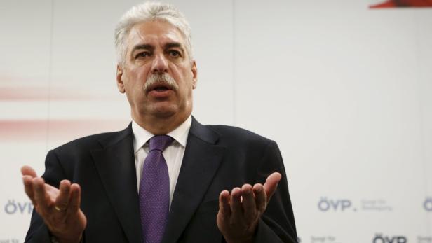 Ein Mann im Anzug gestikuliert vor einem Hintergrund mit dem Logo der ÖVP.