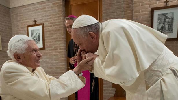 Papst Franziskus küsst seinem Vorgänger Benedikt die Hand