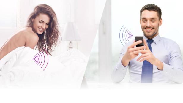 Eine Frau im Bett und ein Mann, der ein Smartphone benutzt.