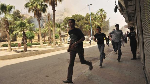 People run for cover after what activists said was shelling by forces loyal to Syria&#039;s President Bashar al-Assad in Raqqa province, eastern Syria May 3, 2013. Picture taken May 3, 2013. REUTERS/Nour Fourat (SYRIA - Tags: CONFLICT CIVIL UNREST)